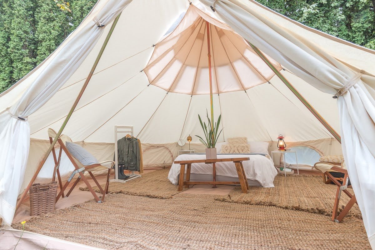 camping tent with a queen bed inside of it and carpeting